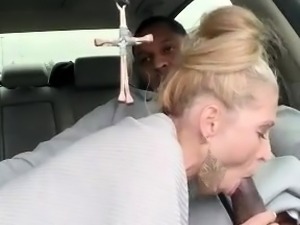Striking blonde milf sucks off a big black cock in the car