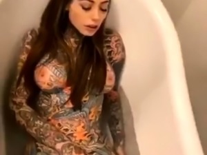 Buxom tattooed babe making herself cum hard in the bathtub